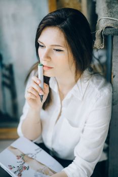 一位女士拿着记号笔，在室内沉思地环顾四周