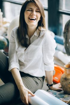 一位身着便装的女子在室内开心地笑着，散发出幸福无忧的气息