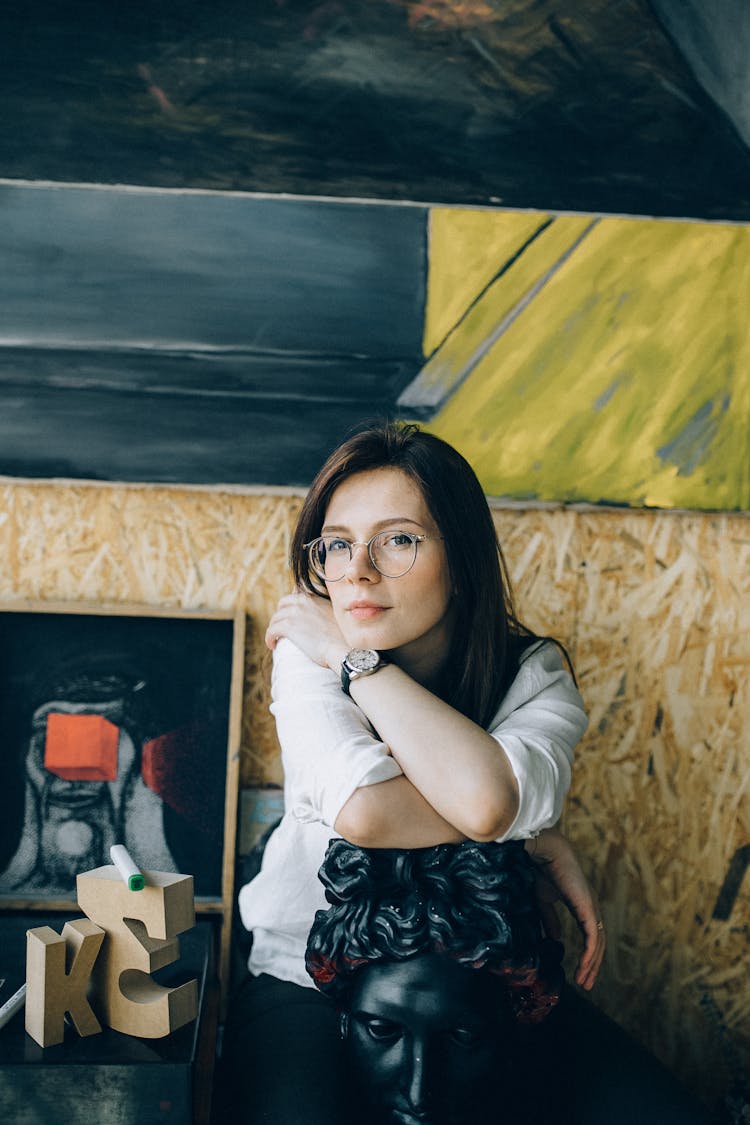 Photo Of Woman In White Top While Leaning On Black Gypsum Head