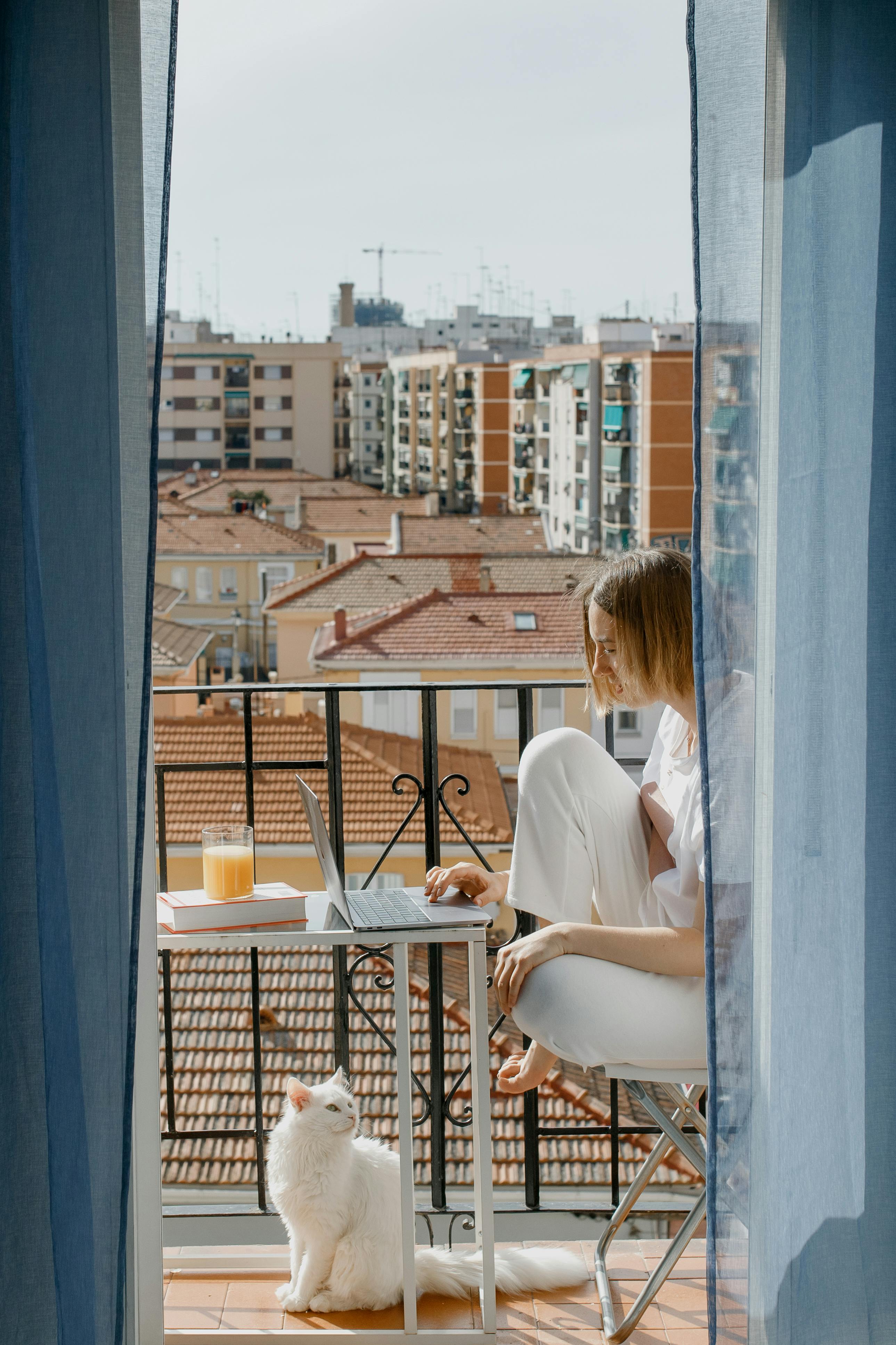 a woman using a laptop in the balcony