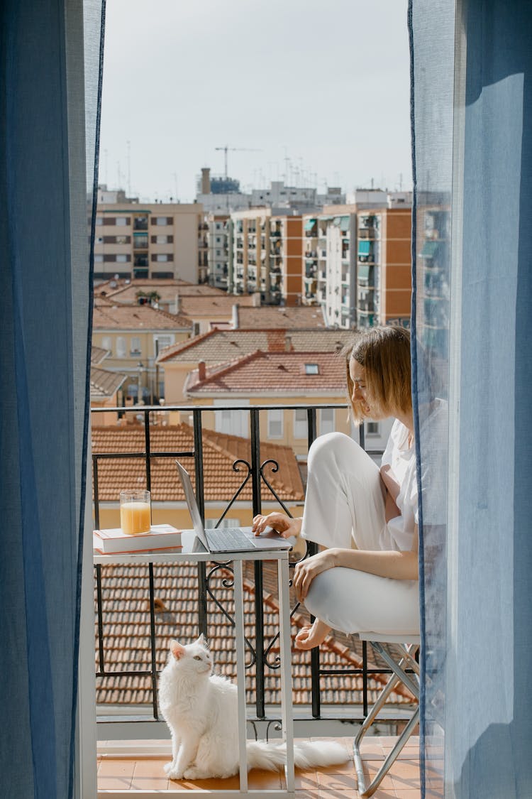 A Woman Using A Laptop In The Balcony