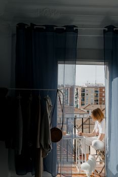 女人和她的狗在阳台上俯瞰城市天际线，远程工作