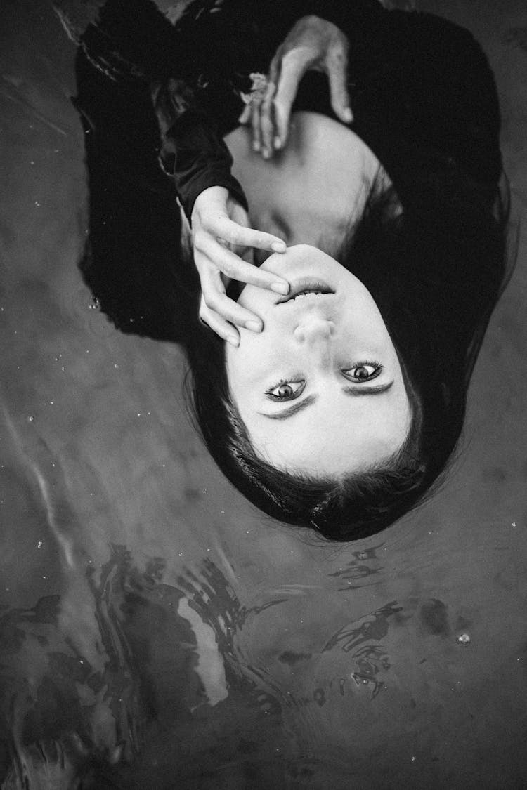 A Woman In Black Swimwear Floating On Water