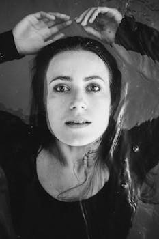 一张黑白肖像中，一个女人漂浮在水里，目光内省