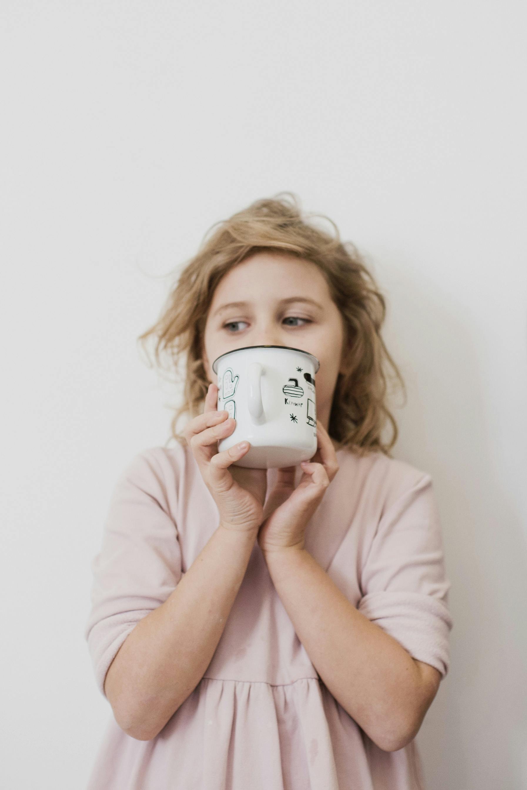 calm girl drinking tasty beverage from white mug