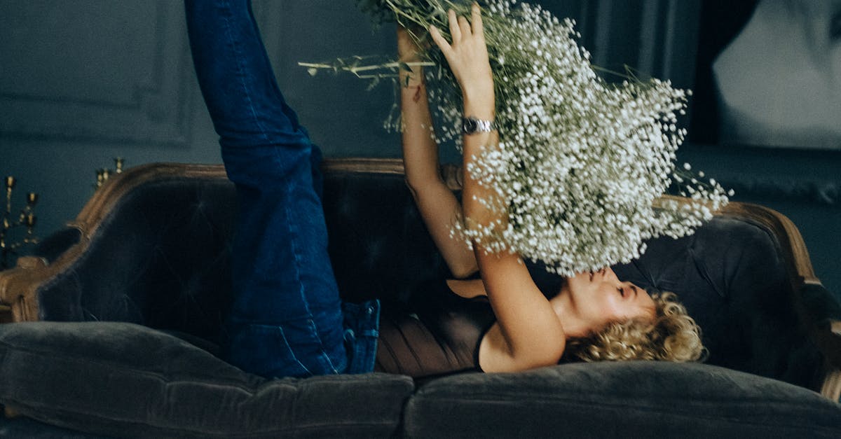 Woman in Blue Denim Jeans Lying on Bed