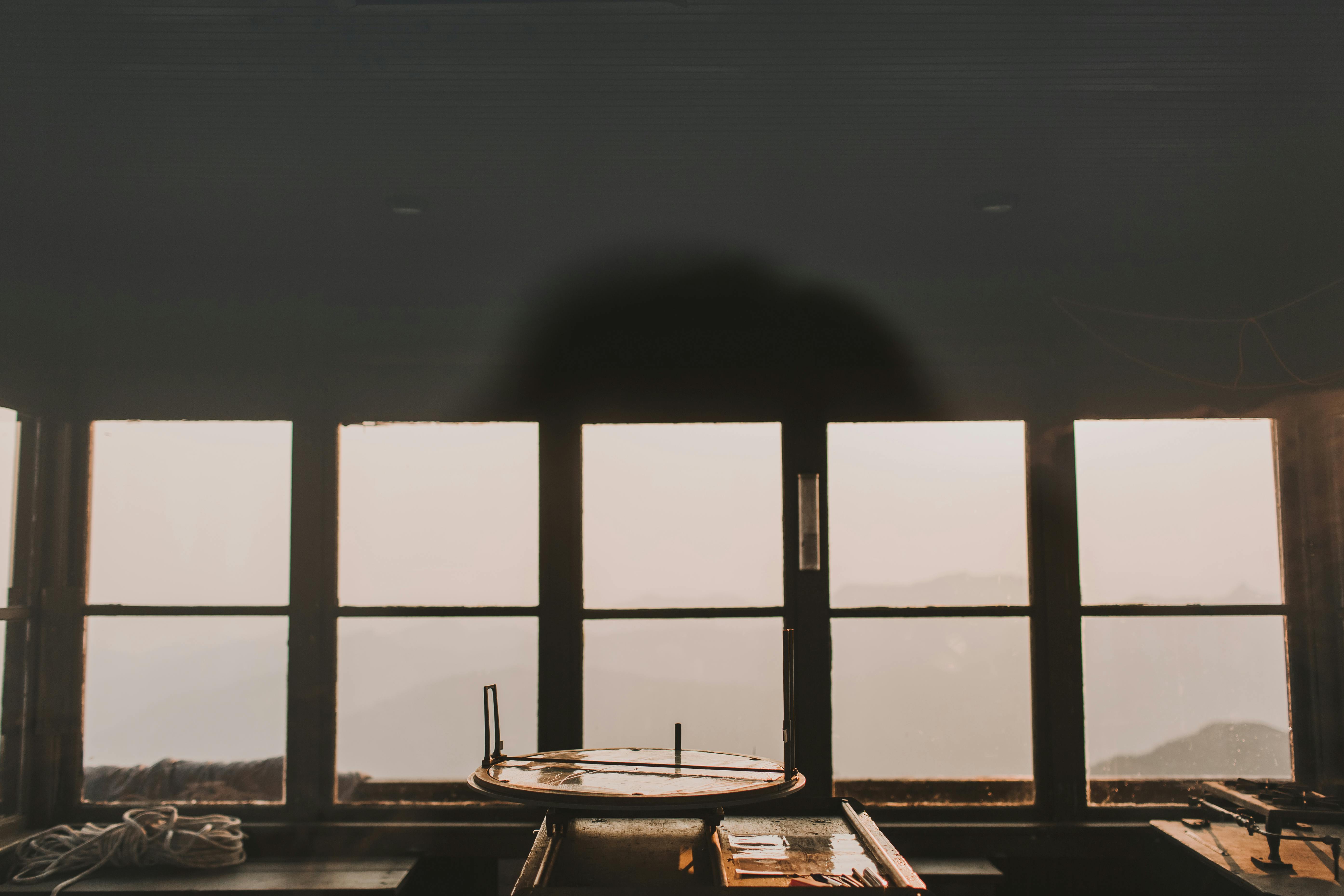 Interior view of a rustic room with windows showcasing a misty mountain sunrise, Ashford, WA.