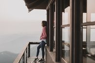 一名妇女站在阳台上，俯瞰着华盛顿州阿什福德雾霭笼罩的山脉