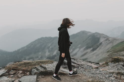 Woman in Black Jacket Standing on the Mountain