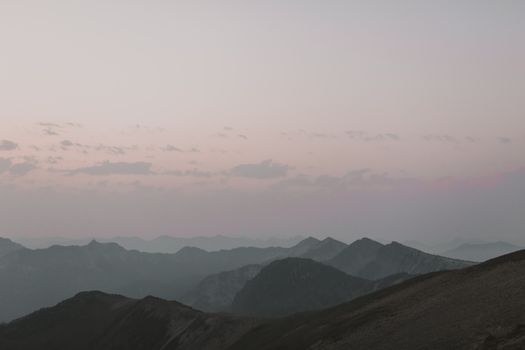 Serene view of the Cascades at sunrise with misty mountain silhouettes.