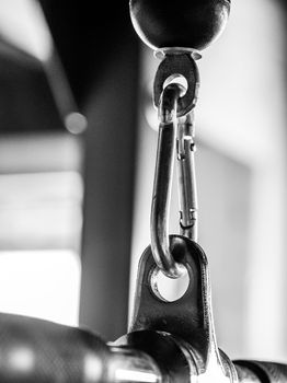 Detailed black and white shot of a carabiner, commonly used for gym equipment safety.
