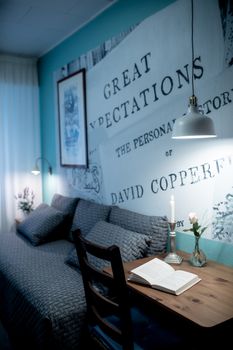 Interior of bright cozy living room decorated with framed picture and phrase on wall