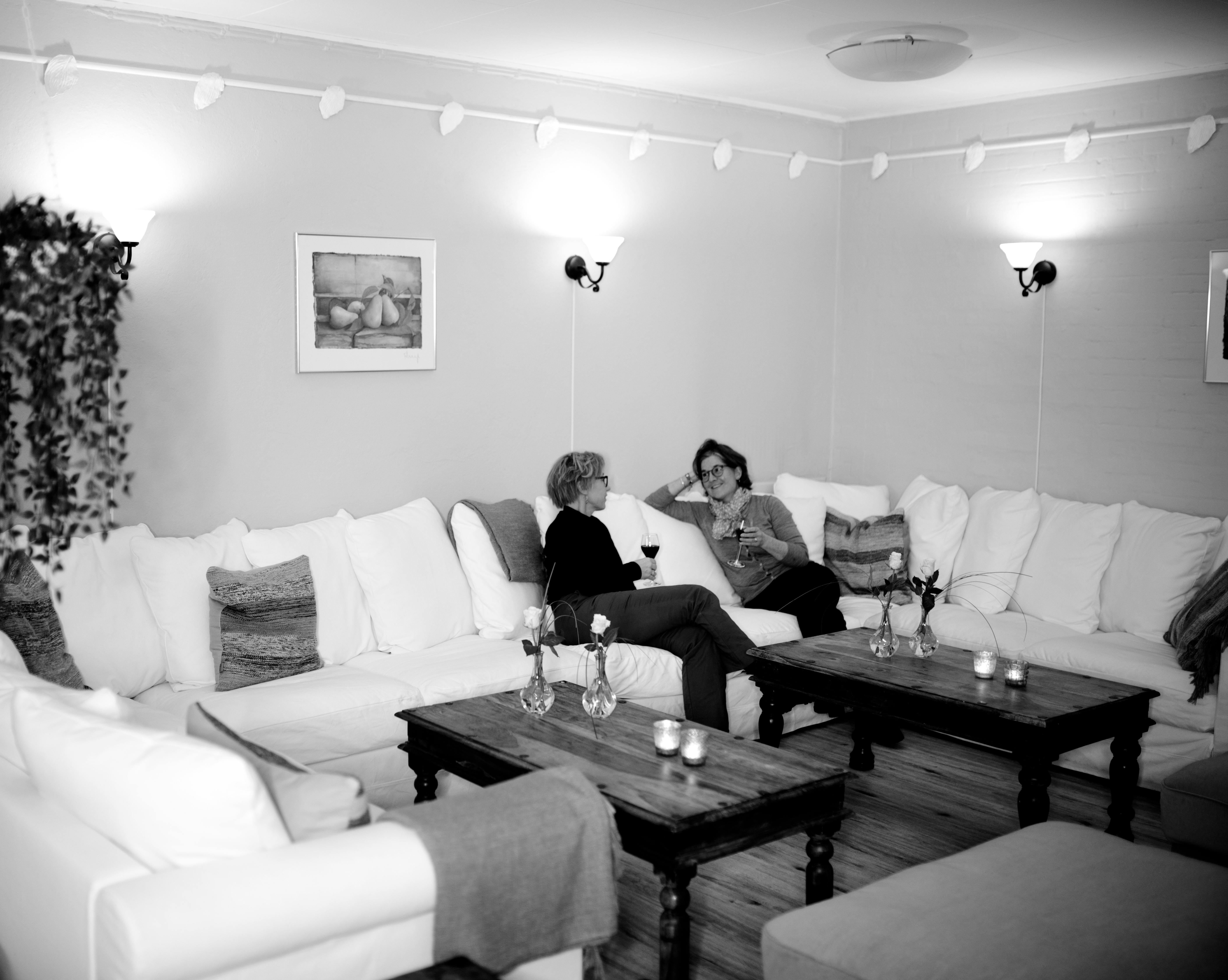 female friends resting and drinking wine in living room