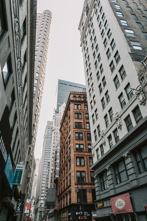 Free A dramatic view of tall skyscrapers in a narrow New York City alleyway, showcasing iconic architecture. Stock Photo