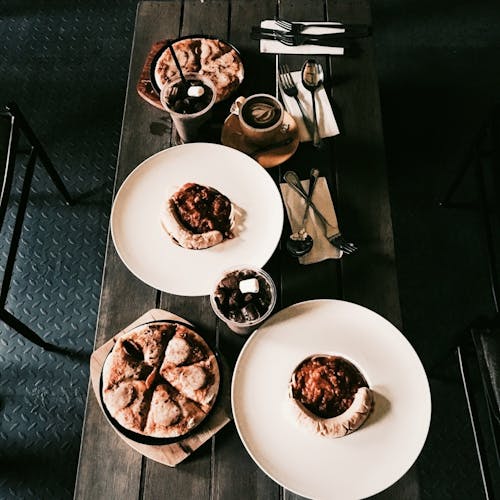 Free Cooked Food on White Ceramic Plates on Wooden Table Stock Photo