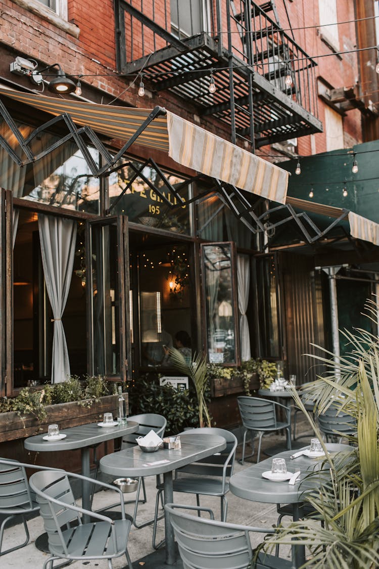 Dining Table And Chairs On The Patio Outside The Building