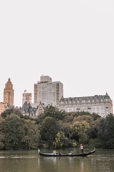 在标志性的纽约市天际线背景下，贡多拉沿着中央公园滑行