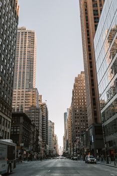 晴朗的天空下，纽约市繁华的街道两旁矗立着高耸的摩天大楼