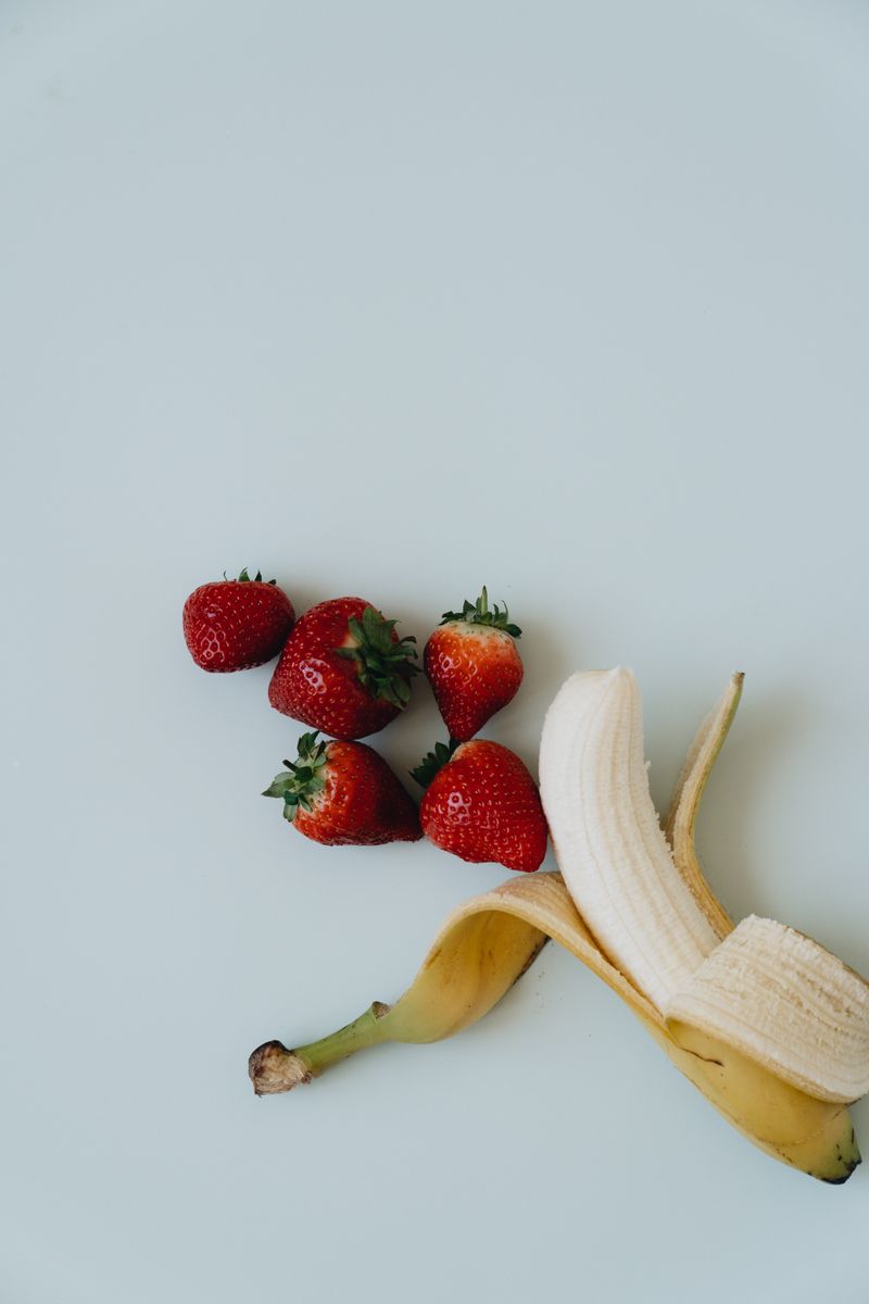Sliced bananas and strawberries on a light background