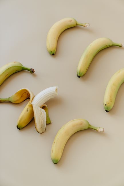 Flat lay of ripe bananas on a beige background creating a minimalist look.