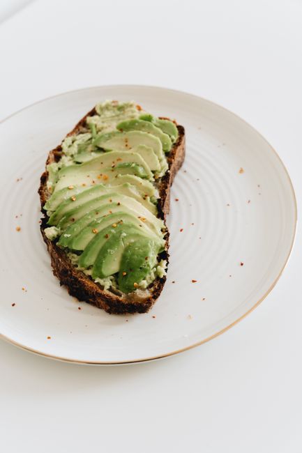 Sliced avocado on rustic bread, garnished with spices, showcasing a healthy and tasty snack.