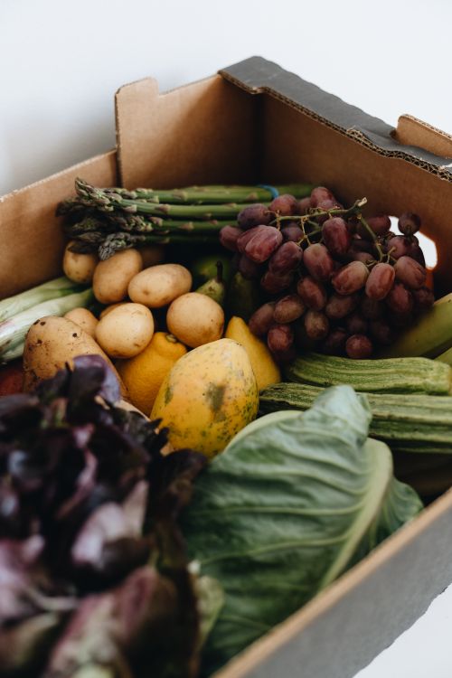 Free Close-up of a cardboard box filled with fresh vegetables and fruits, perfect for healthy living. Stock Photo