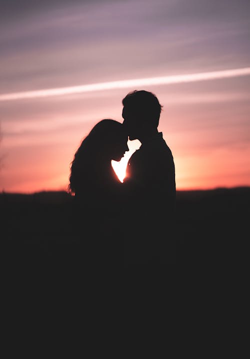 A Silhouette of a Couple Kissing