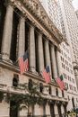 纽约证券交易所位于美国华尔街，其标志性建筑上悬挂着美国国旗