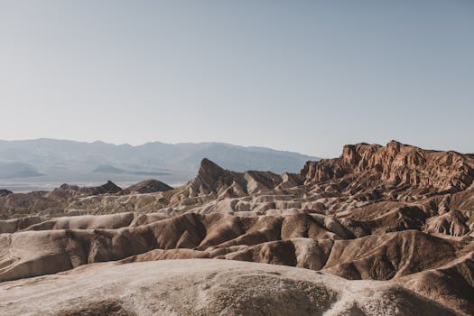 Breathtaking landscape of Death Valley's rugged terrain under a clear blue sky.