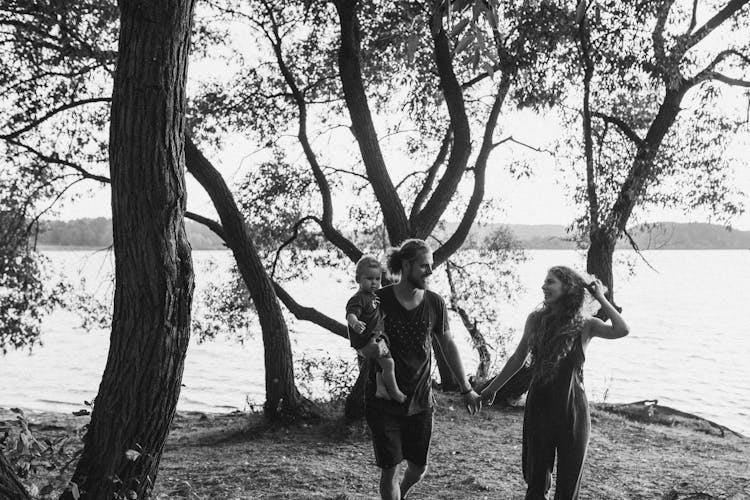 Grayscale Shot Of A Family Under The Tree