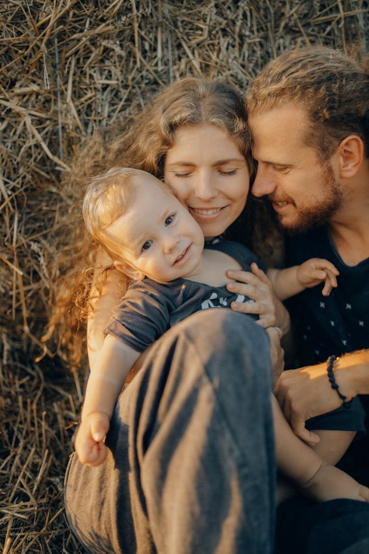 Happy Couple Sitting With Their Baby