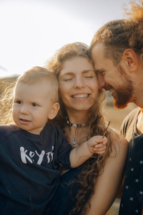 Free Joyful family enjoying a sunny day outdoors, embracing and smiling. Stock Photo