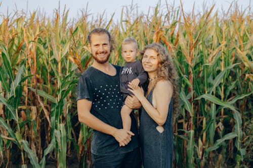 A Lovely Family Standing in the Corn Field