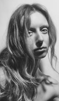 Artistic grayscale portrait of a woman with long wavy hair, captured in Kyiv, Ukraine.