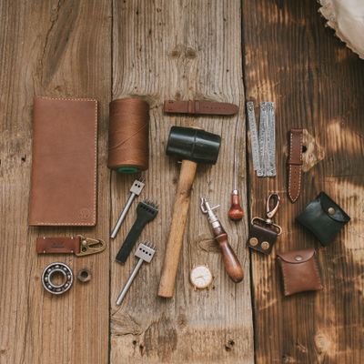 Leather working tools laid out on a wooden bench — photo by Vlada Karpovich on Pexels