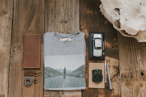 Gray T-Shirt and Car Model on Wooden Floor