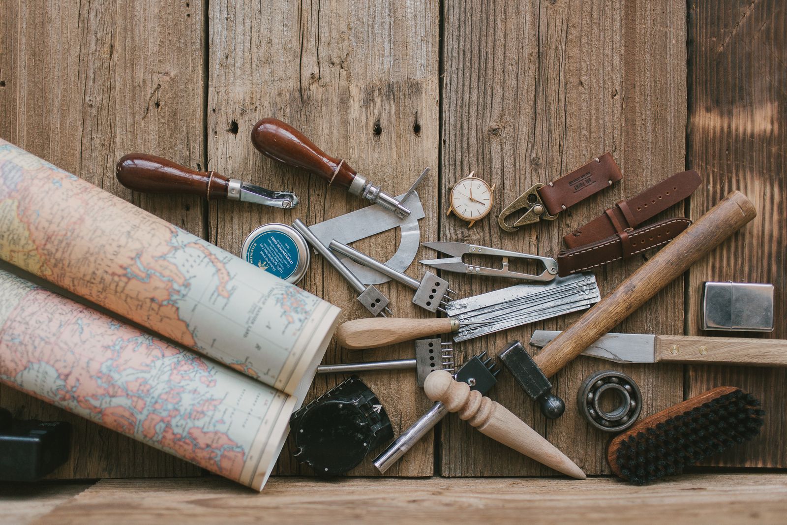 Leather-working tools laid out on a wooden bench, photo by Vlada Karpovich on Pexels