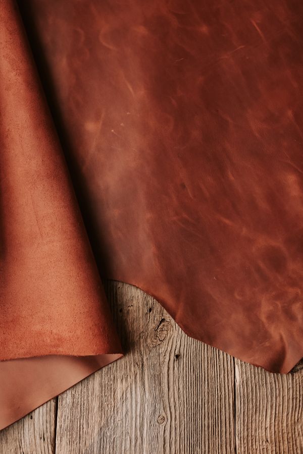 Roll of vegetable-tanned leather on a rustic workbench — photo by Vlada Karpovich on Pexels