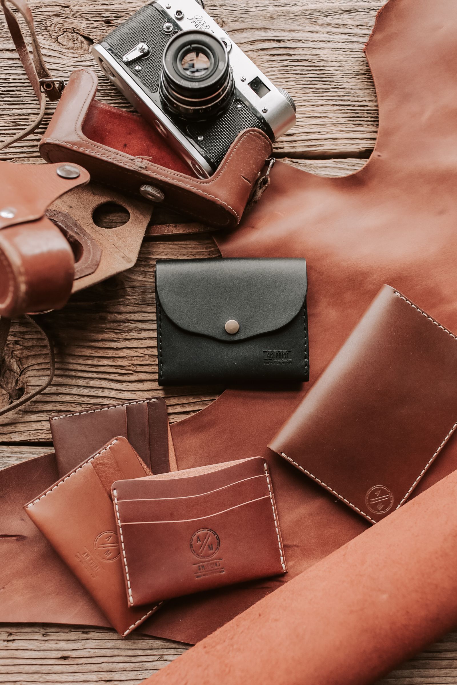 Collection of handcrafted brown leather wallets on a wooden table
