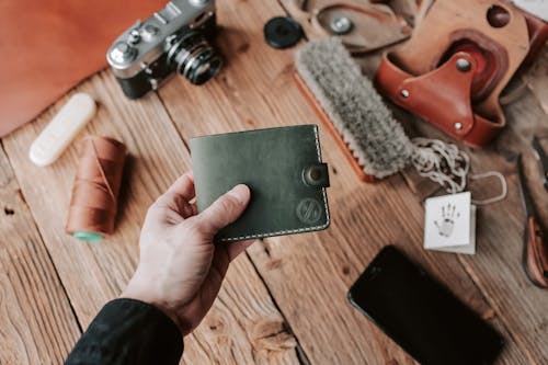 Free Shallow Focus Photo of Person Holding Black Leather Wallet Stock Photo