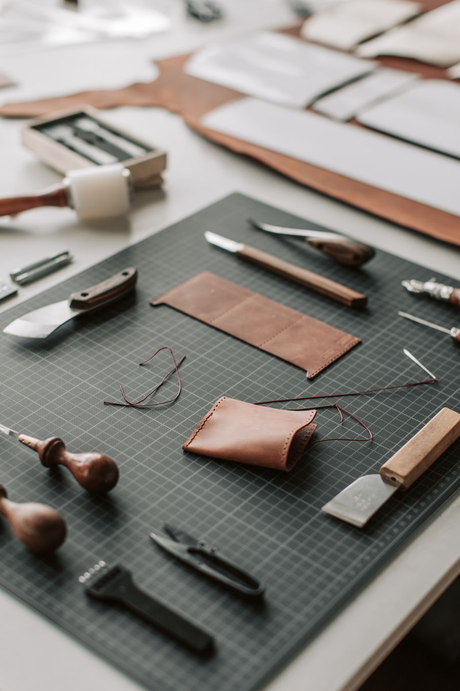 Leather crafting tools and materials laid out on a workbench