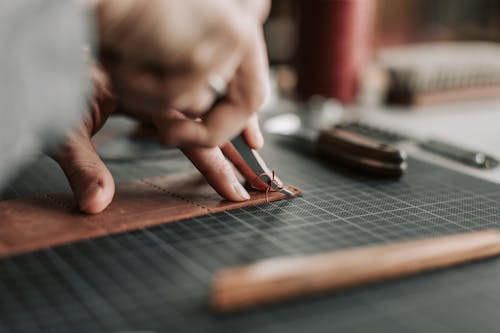 Close-up of a Leathersmith Cutting Brown Leather 