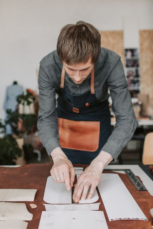 Free A craftsman skillfully cutting leather in a workshop setting, focusing on precision work. Stock Photo