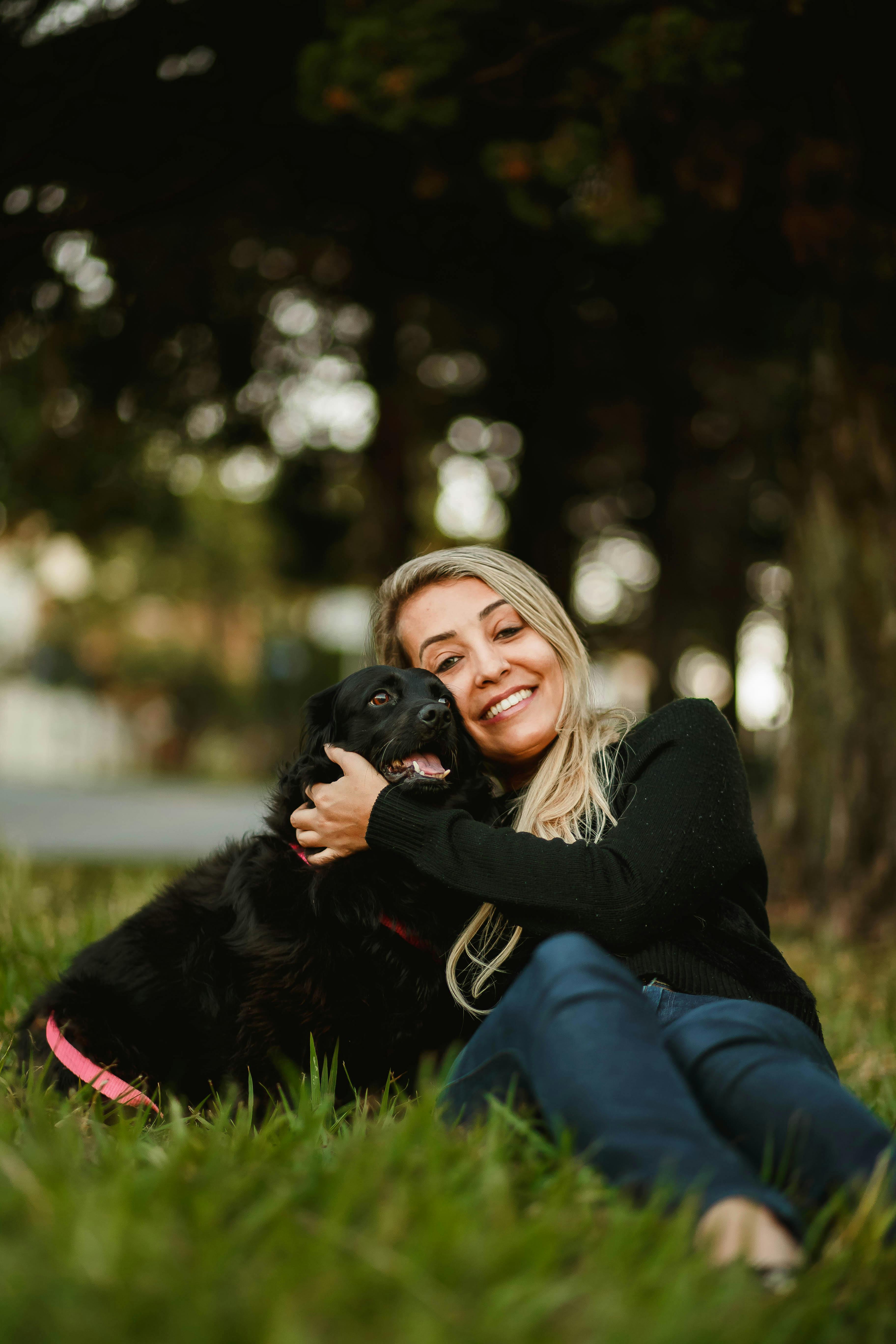 Smiling woman with cute dog on lawn