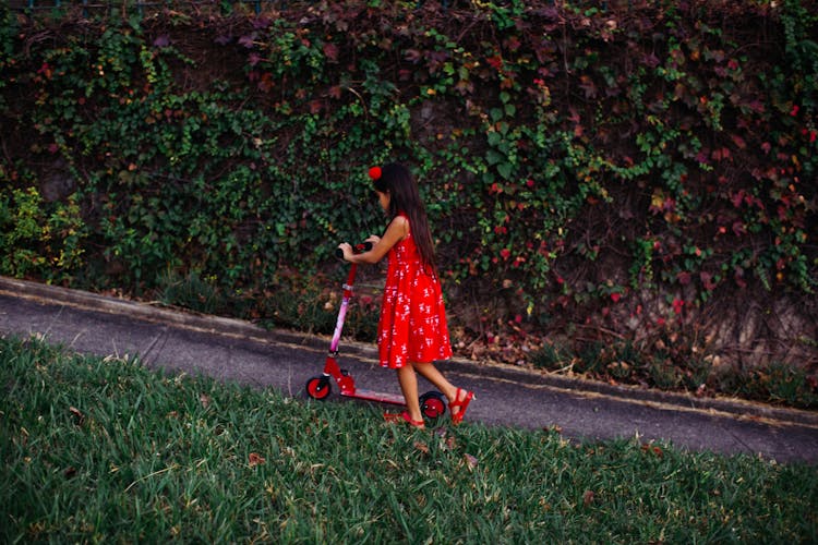 Girl Riding Scooter In Park