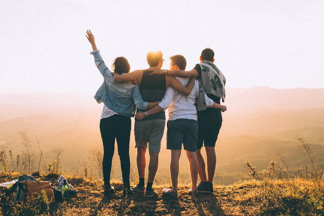 Gratis Amigos Anónimos Parados Juntos Al Atardecer En Las Montañas Foto de stock