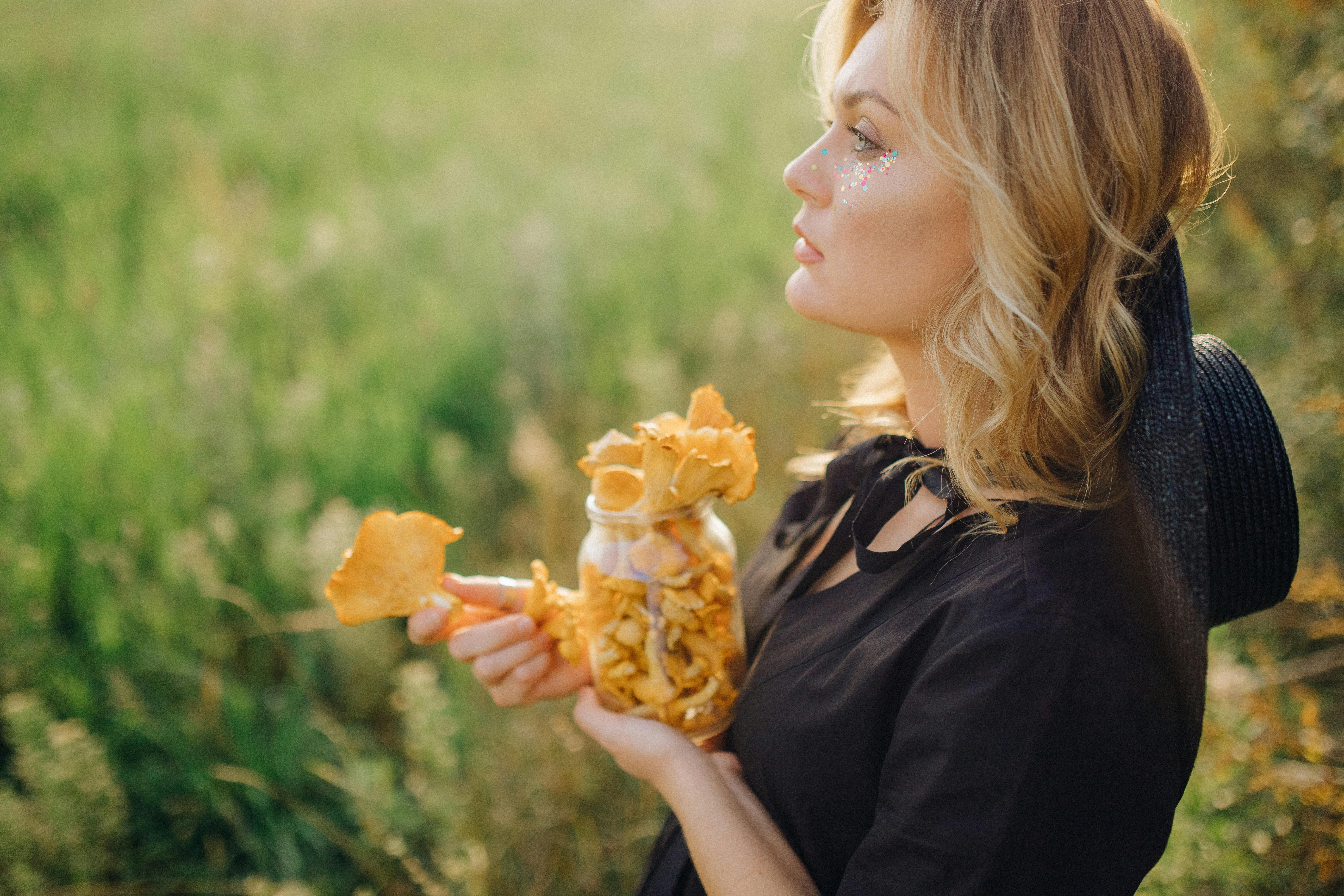 girl in black shirt holding yellow flower