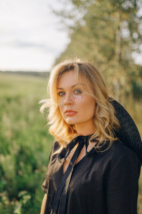 Girl in Black Jacket Standing on Green Grass Field