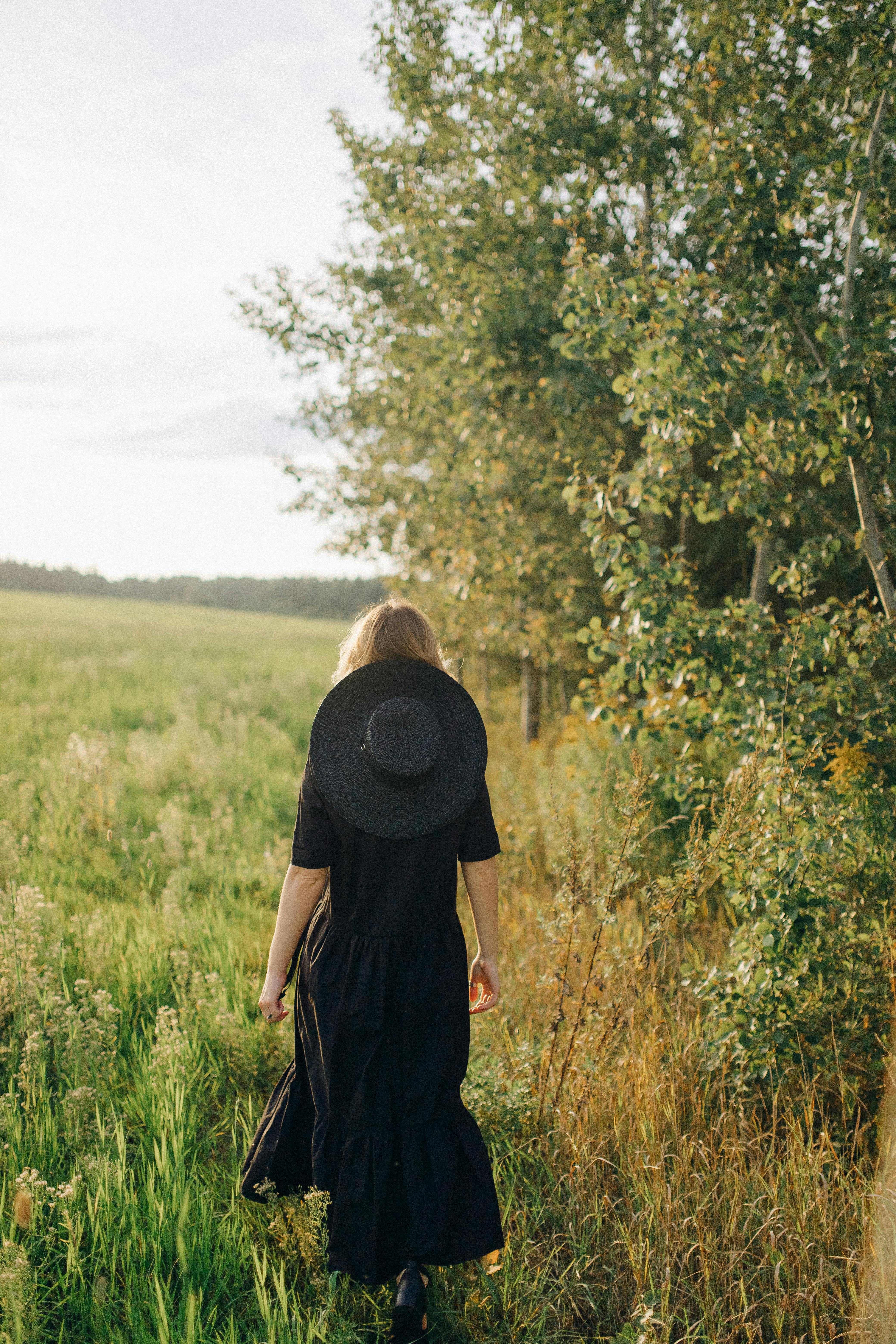 woman in black dress standing on green grass field