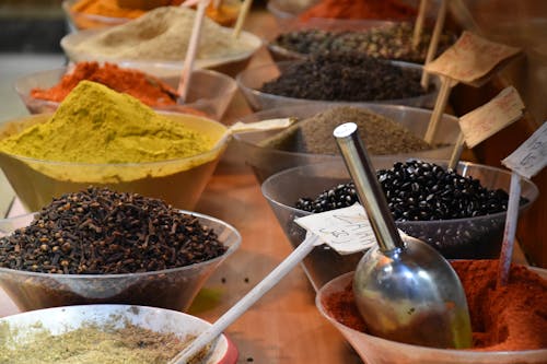 Free From above of bowls full of various dry seasonings on table in street bazaar Stock Photo